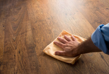 Man wiping down new hardwood with cloth
