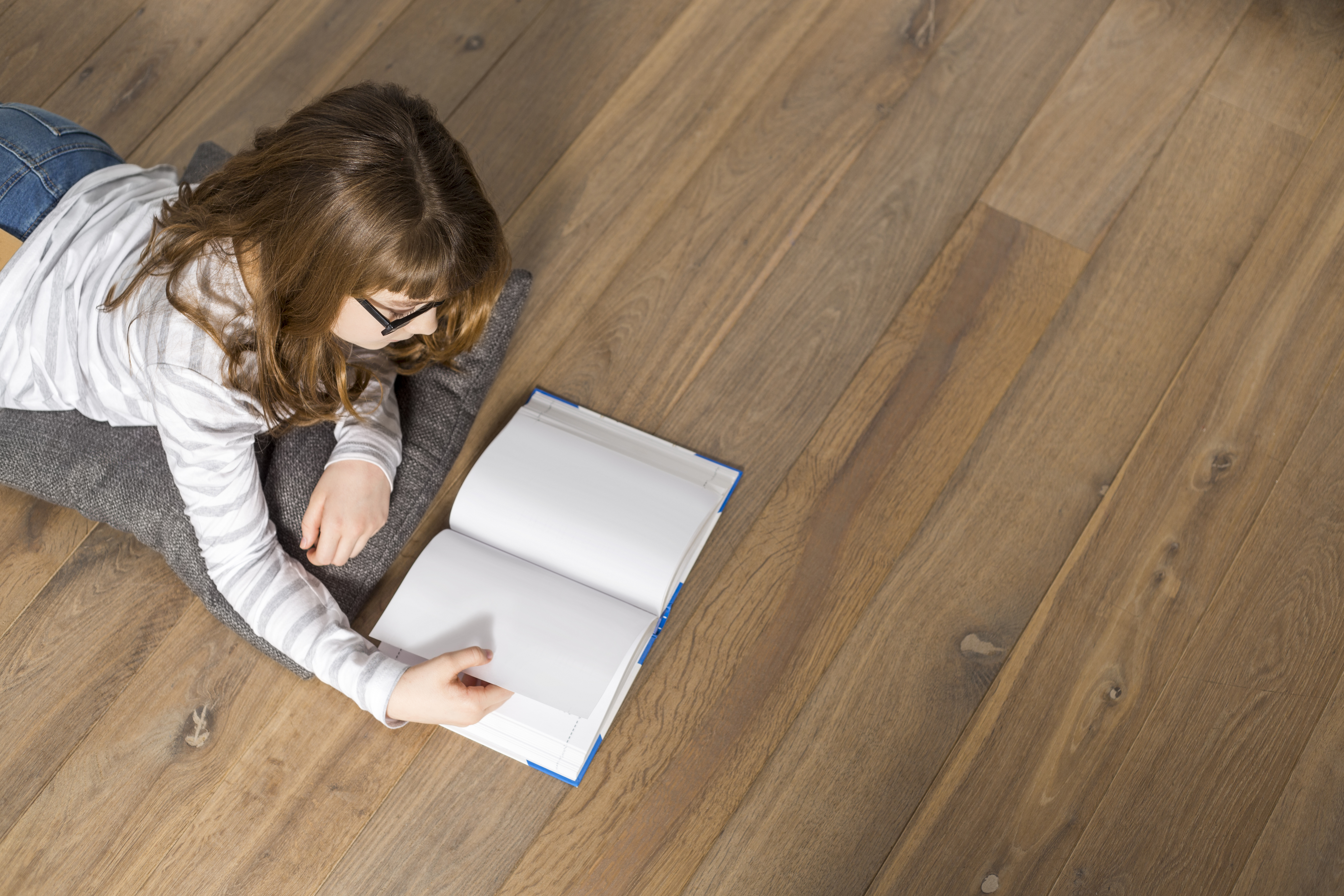Hardwood Species Featured Image of a Child Reading on a Hardwood Floor