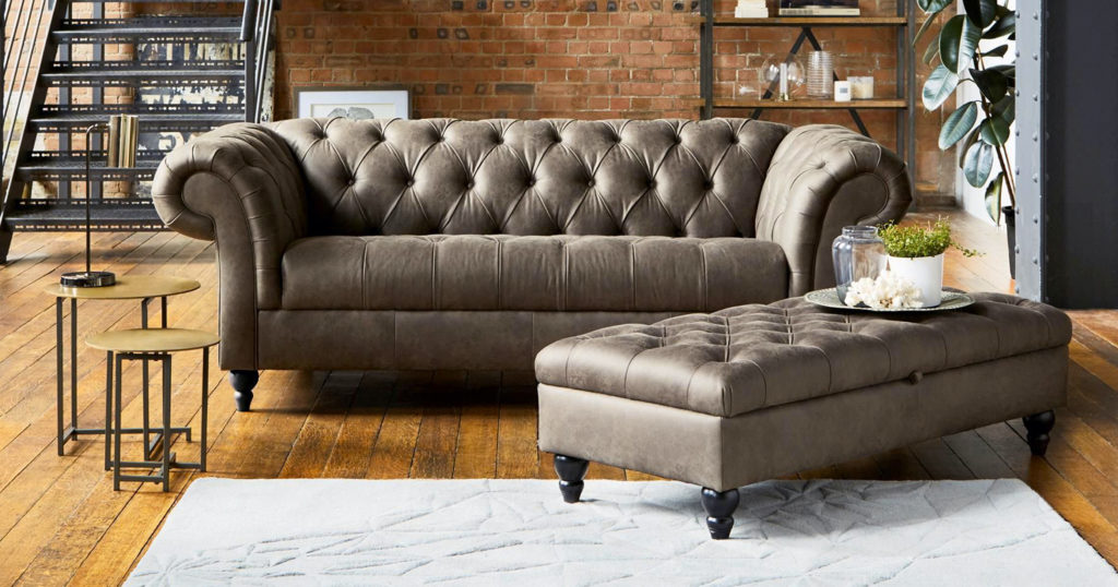 Old fashioned leather couch on wood floor in exposed brick and metal loft