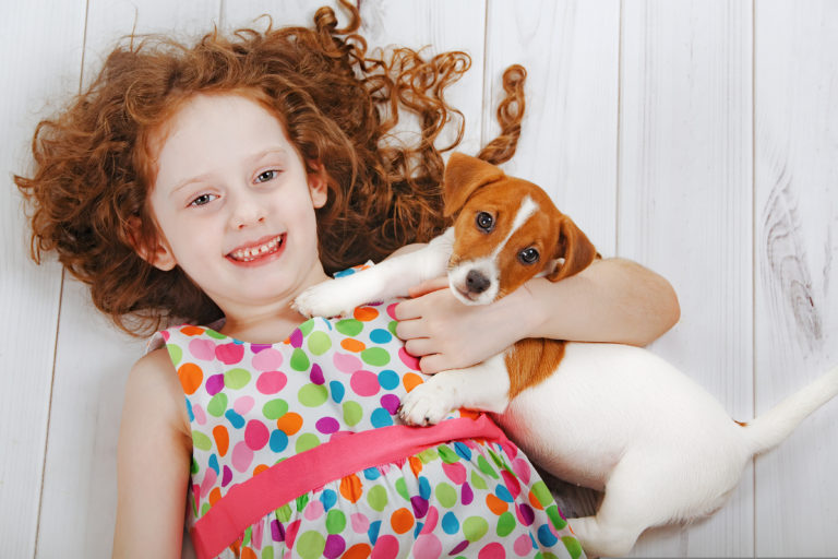 Sustainable Wood Flooring Featured Image of Redhead Child on White Wood Floor with Small Terrier Dog