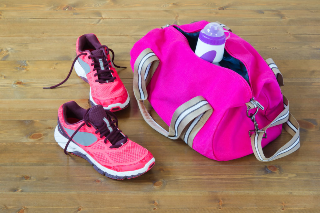 Pink gym bag and shoes on wood-look resilient floor