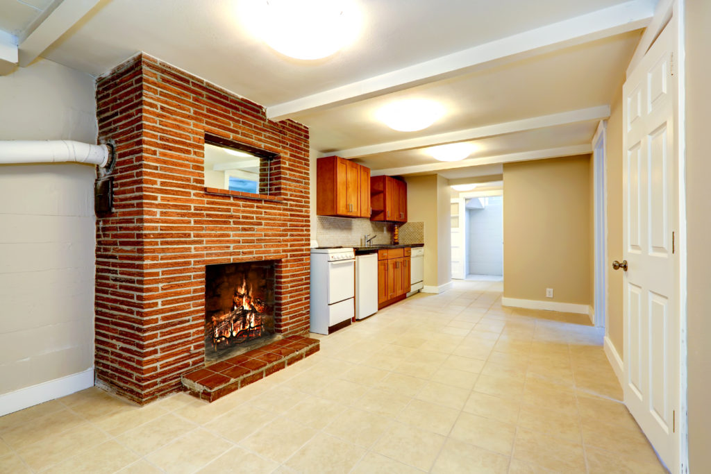Tile flooring in a basement kitchenette with fireplace