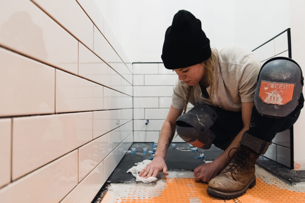 Flooring professional installing porcelain tile in a shower